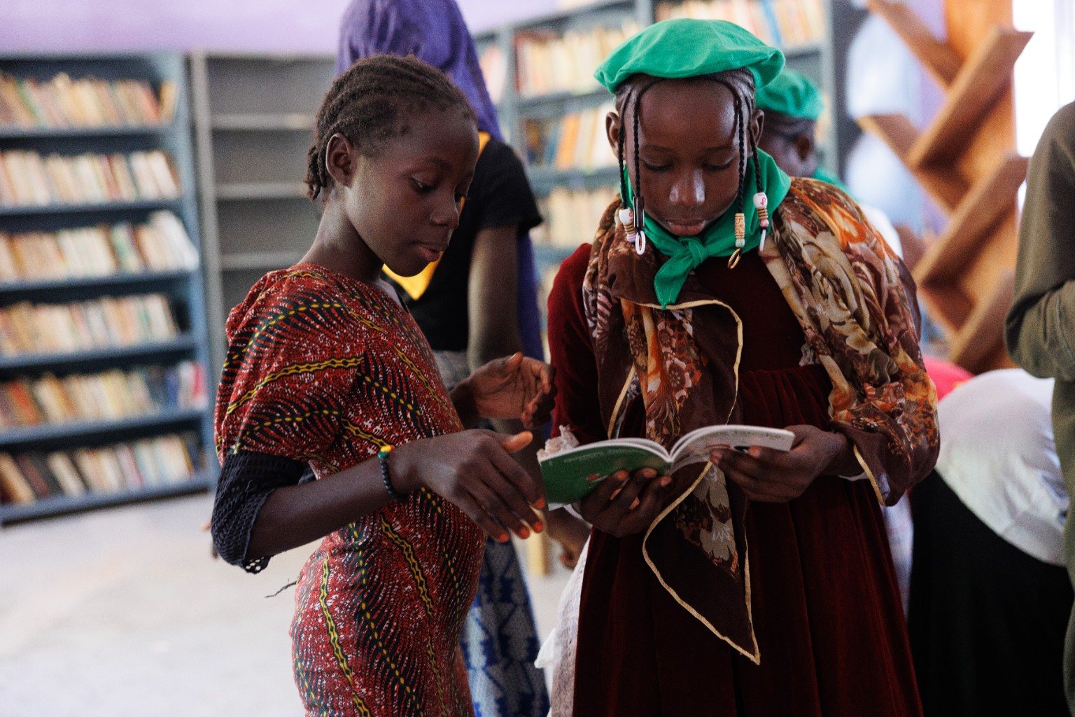Deux jeunes filles lisent ensemble un livre dans la bibliothèque